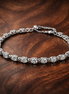 Bow Chain Bracelet — display on walnut