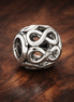 Silver Infinity Knot Bead - Silver Infinity Loop Charm — display on walnut