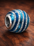 Blue Ribbed Sparkle Bead - Blue Ribbed Enamel Sparkle Bead — display on walnut