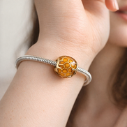 Amber Honeycomb Bead - Amber Honeycomb Enamel Charm — worn on wrist