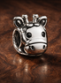 Giraffe Face Charm - Smiling Giraffe Face Charm — display on walnut