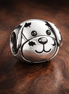 Dog Face Charm - Smiling Dog Face Charm — display on walnut
