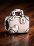 Pink Travel Bag Charm — display on walnut