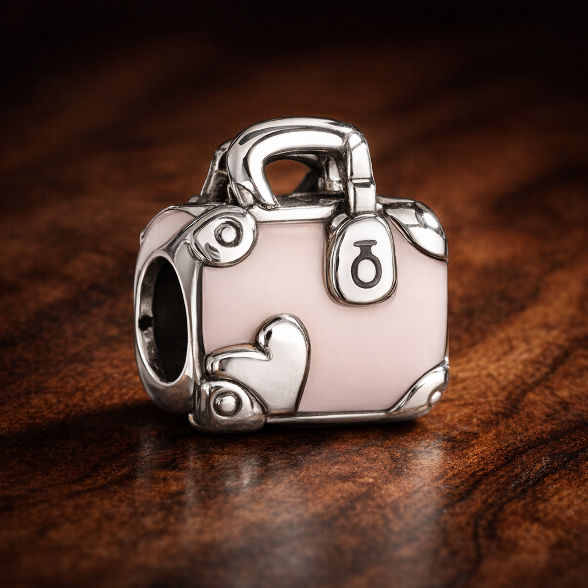 Pink Travel Bag Charm — display on walnut
