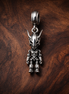 Abstract Dangle Charm - Minimal Abstract Dangle Charm — display on walnut