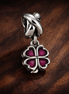 Purple Clover Charm - Purple Four Leaf Clover Charm — display on walnut