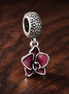 Pink Flower Charm - Pink Enamel Flower Dangle Charm — display on walnut