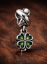 Green Clover Charm - Green Four Leaf Clover Charm — display on walnut