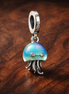 Color-changing Jellyfish Dangle Charm — display on walnut