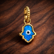 Opalescent Blue Hamsa Hand Dangle Charm — display on walnut