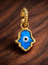 Opalescent Blue Hamsa Hand Dangle Charm — display on walnut