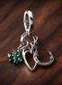 Four Leaf Clover, Heart and Horseshoe Triple Dangle Charm — display on walnut