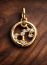 Aries Zodiac Charm - Gold Plated Aries Zodiac Charm — display on walnut