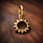 Gold Plated Sun Outline Charm - Gold Plated Open Sun Dangle Charm — display on walnut