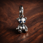 Movable Teddy Bear Dangle Charm — display on walnut