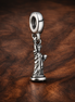 New York Statue of Liberty Dangle Charm — display on walnut