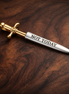 Not Today Sword Charm - Not Today Sword Dangle Charm — display on walnut