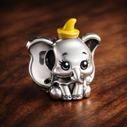 Disney Dumbo Charm — display on walnut