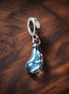 Blue Glass Slipper Trio Charm - Blue Glass Slipper Trio Charm — display on walnut