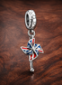 Union Jack Pinwheel Charm - Union Jack Pinwheel Charm — display on walnut