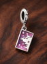 Purple Ticket Dangle Charm - Purple Ticket Dangle Charm — display on walnut
