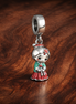Holiday Doll Trio Dangle - Holiday Doll Trio Dangle Charm — display on walnut