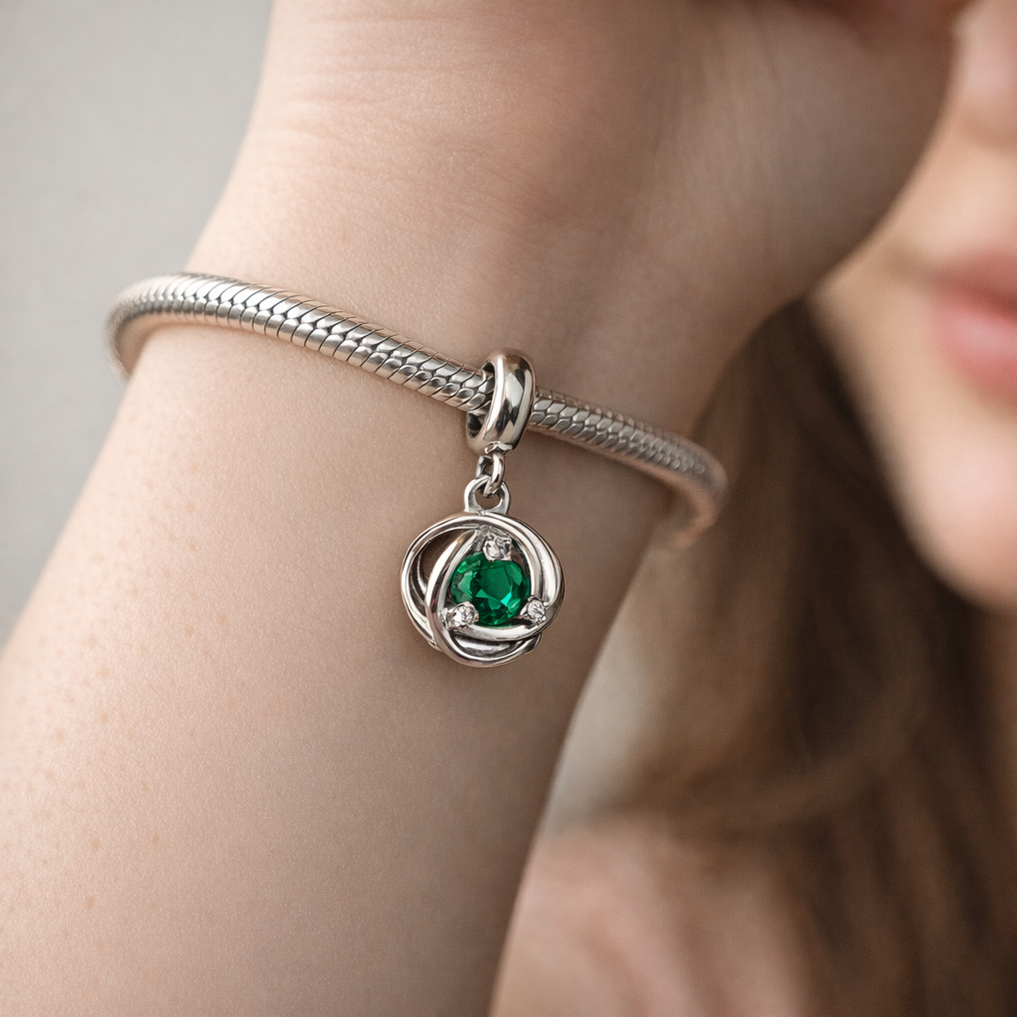 Green Eternity Circle Dangle Charm — worn on wrist