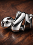 Cute White Sloth Charm — display on walnut