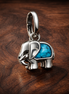 Turquoise-colored Elephant Mini Dangle Charm — display on walnut
