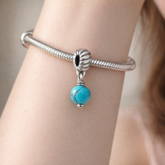 Turquoise-colored Dangle Charm — worn on wrist