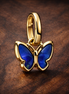 Blue Butterfly Mini Dangle Charm — display on walnut