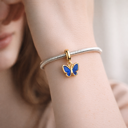 Blue Butterfly Mini Dangle Charm — worn on wrist