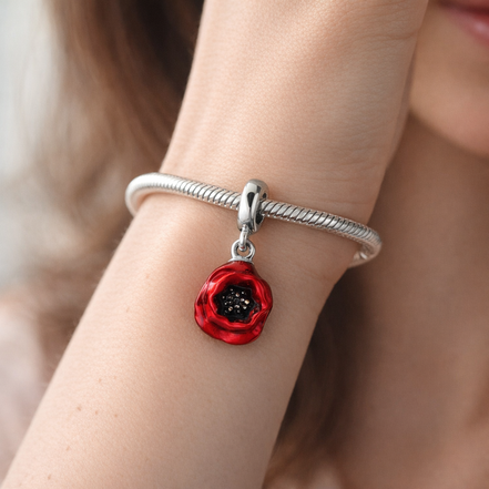 Red Flower Dangle Charm — worn on wrist
