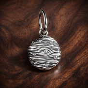 Engravable Mini Medallion Charm — display on walnut