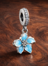 Blue Blossom Dangle Charm — display on walnut