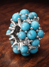 Turquoise-colored Ocean Charm — display on walnut
