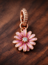 Pink Daisy Flower Dangle Charm — display on walnut