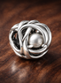 April Clear Eternity Circle Charm — display on walnut