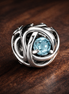 March Sea Aqua Blue Eternity Circle Charm — display on walnut