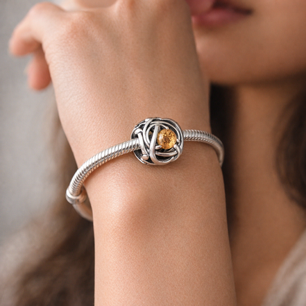January Red Eternity Circle Charm — worn on wrist