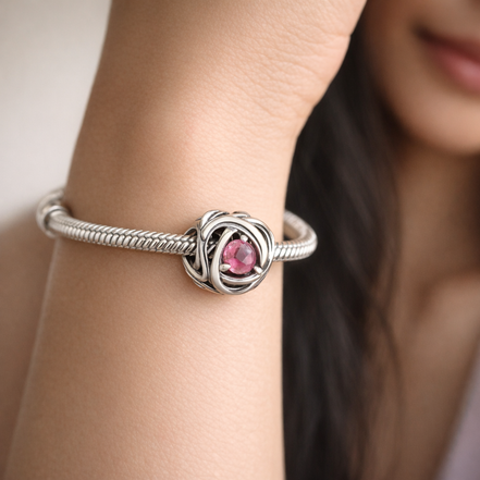 October Pink Eternity Circle Charm — worn on wrist