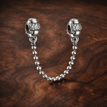 Silver Ball Safety Chain Charm - Silver Ball Safety Chain Charm — display on walnut