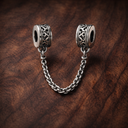 Silver Logo Safety Chain Charm - Silver Logo Safety Chain Charm — display on walnut