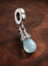 Baby Bottle Blue Dangle Charm - Baby Bottle Blue Dangle Charm — display on walnut