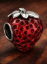 Seeded Strawberry Fruit Charm — display on walnut