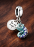 Color-changing Chameleon Dangle Charm — display on walnut