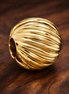 Gold Plated Ribbed Shell Charm - Gold Plated Ribbed Shell Charm — display on walnut