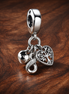 Family Infinity Triple Dangle Charm — display on walnut