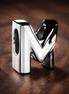 Letter M Alphabet Charm — display on walnut