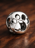 Openwork Paw Print Charm — display on walnut